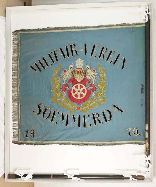 Die restaurierte Fahne mit der aufgestickten Aufschrift Militair-Verein Soemmerda 1879 sowie ein Wappen umrankt von zwei goldenen Lorbeerzweigen. Foto: Christine Supianek